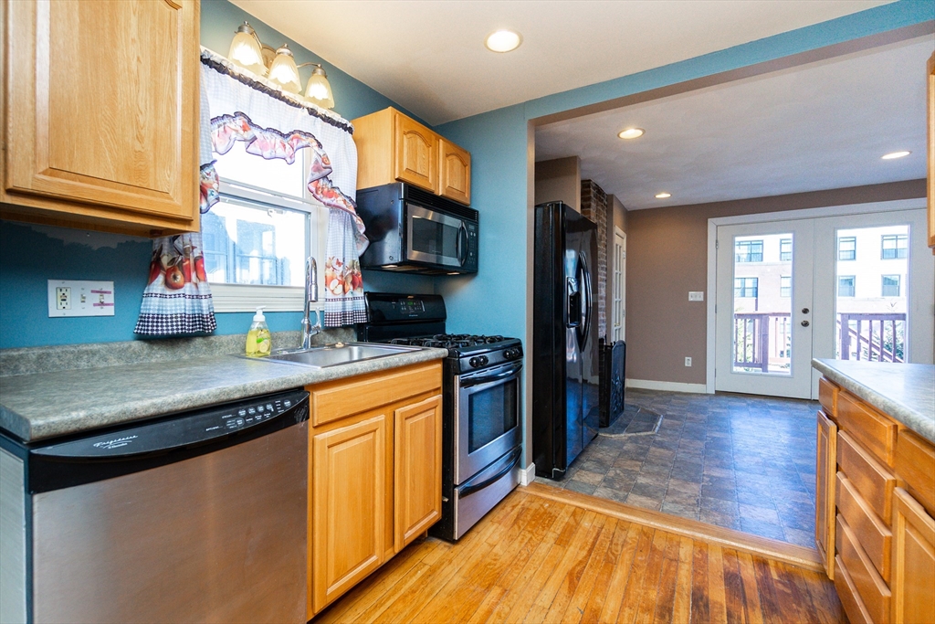 86 Flint Street Salem, MA 01970 - Photo 17 of 30 a kitchen with stainless steel appliances granite countertop a sink and a stove top oven