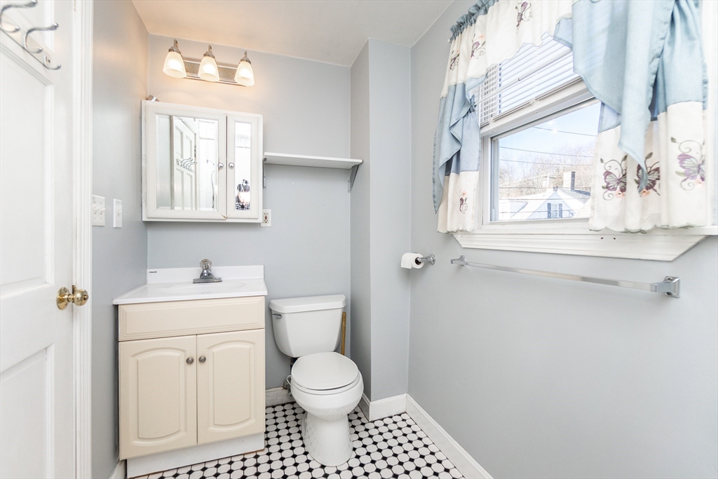 86 Flint Street Salem, MA 01970 - Photo 23 of 30 a bathroom with a toilet a sink a mirror and a window