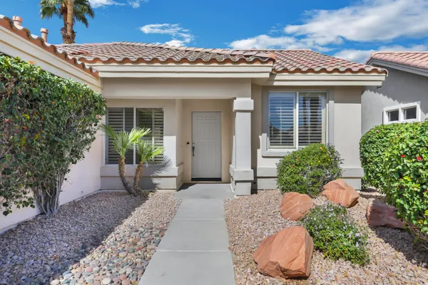 a view of an empty room with a window and a kitchen