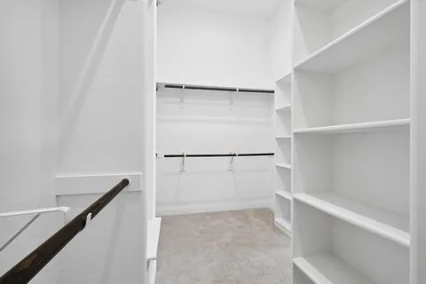 a view of walk in closet with empty racks
