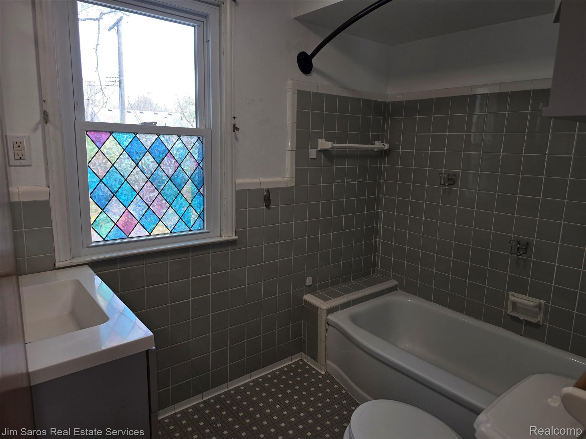 1762 Bournemouth Road Grosse Pointe, MI 48236 - Photo 16 of 21 Full bath with vanity, tile walls, shower combination, and a wainscoted wall