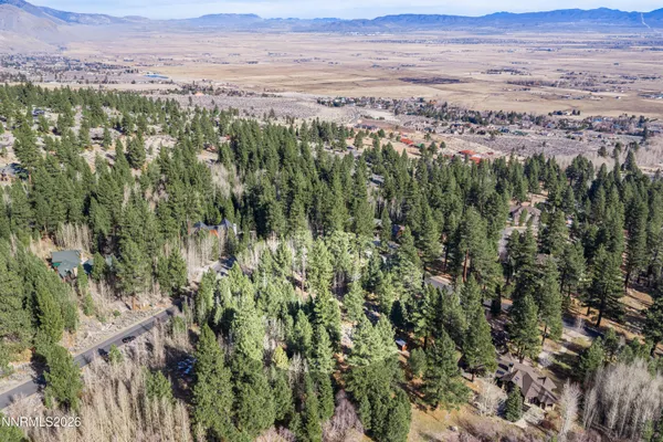 an aerial view of residential houses with outdoor space and mountain view