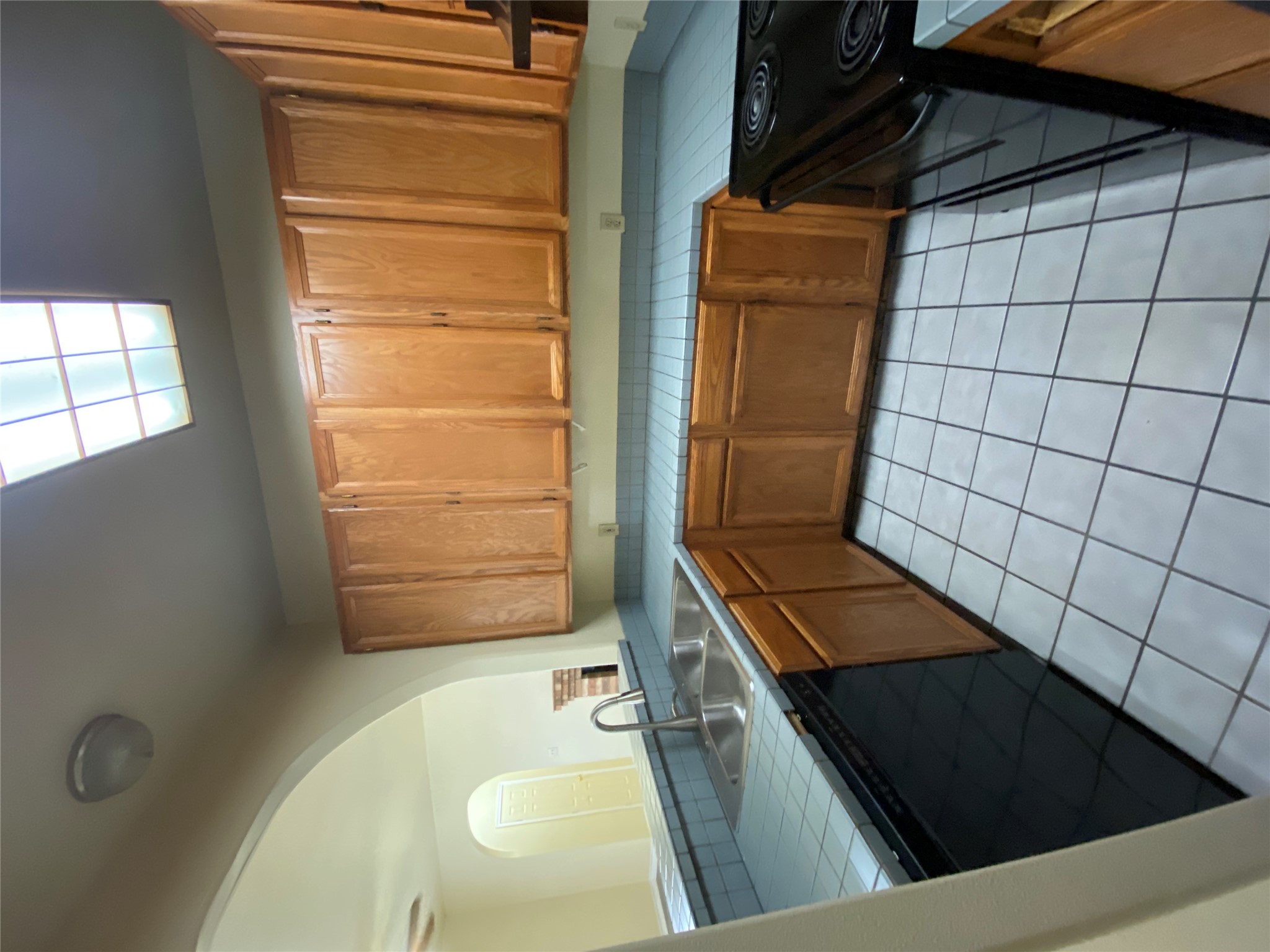 2605 Alcott Lane, Unit B Austin, TX 78748 - Photo 4 of 15 Well-lit kitchen with a double sink, ample cabinetry, and practical tile surfaces.