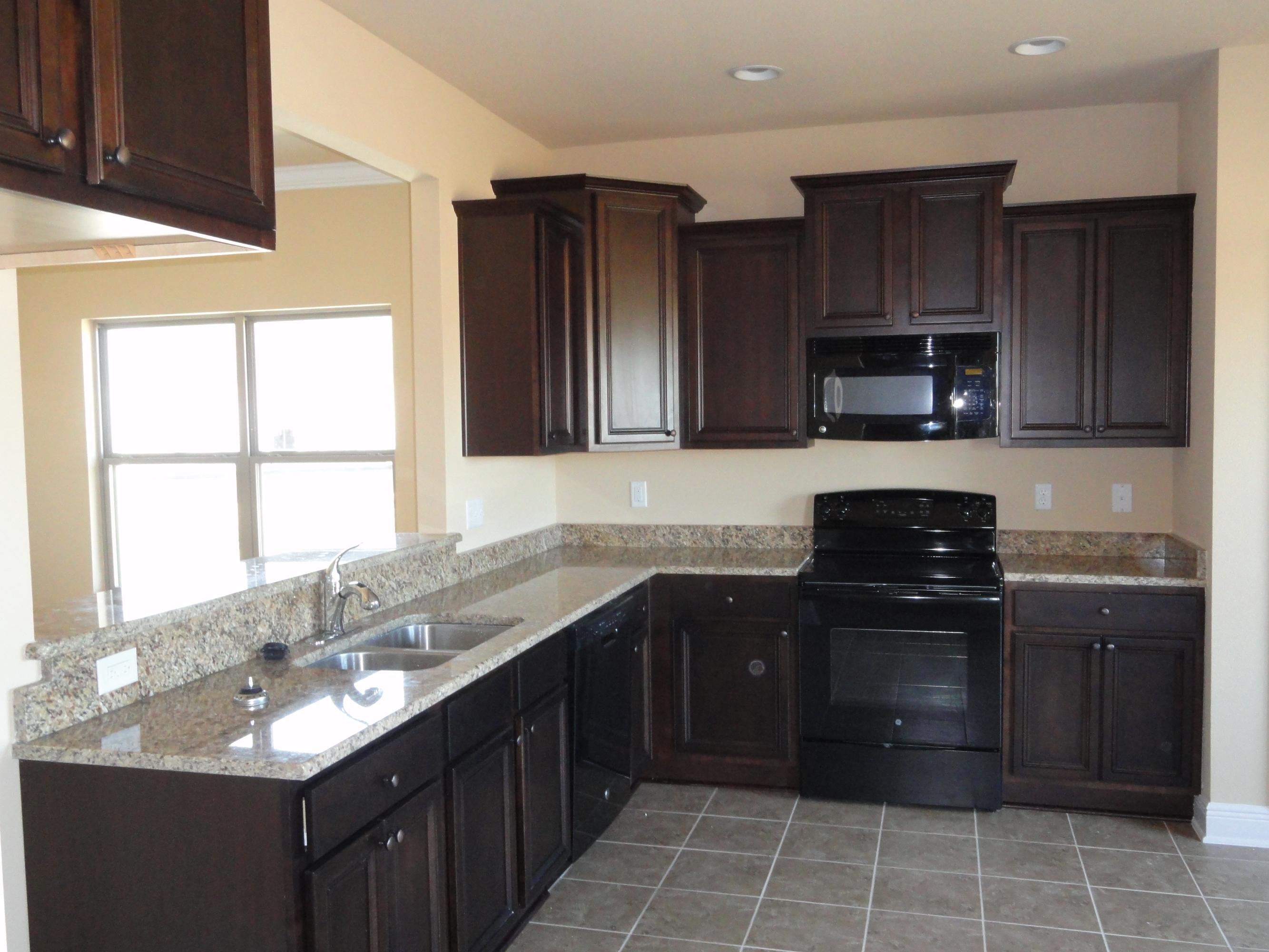 3443 Brownstone Road Crestview, FL 32539 - Photo 4 of 6 a kitchen with a sink stove top oven and wooden cabinets