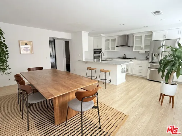 a open dining room with kitchen island a table and chairs