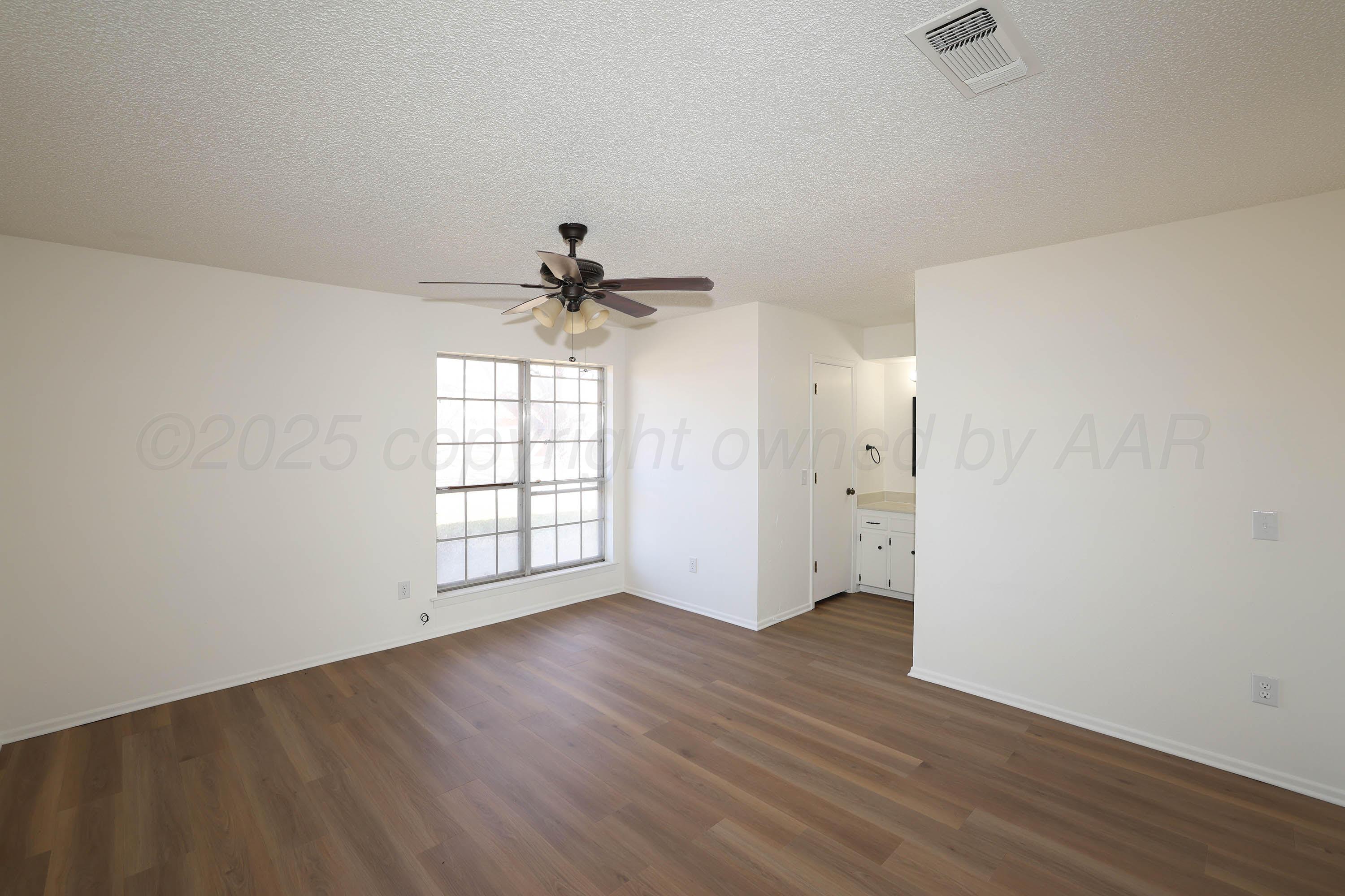 4415 Kingston Road Amarillo, TX 79109 - Photo 11 of 26 an empty room with wooden floor and windows