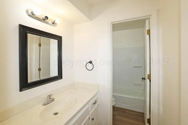 a bathroom with a tub sink and mirror