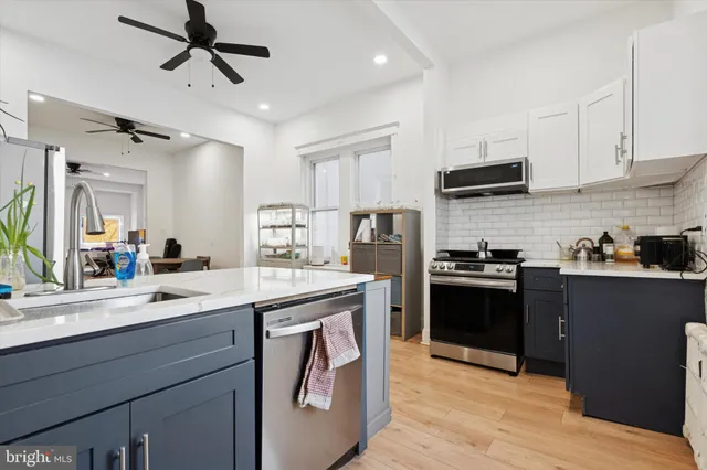 a kitchen with kitchen island white cabinets appliances and sink