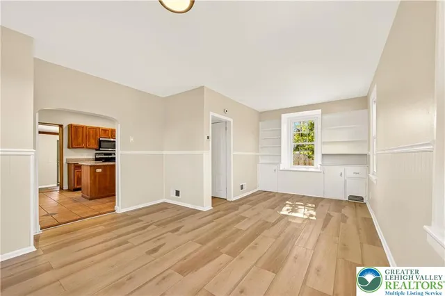 a view of a kitchen with wooden floor and a refrigerator