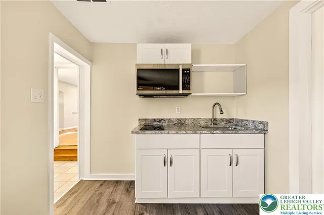 a kitchen with granite countertop a sink and a stove top oven