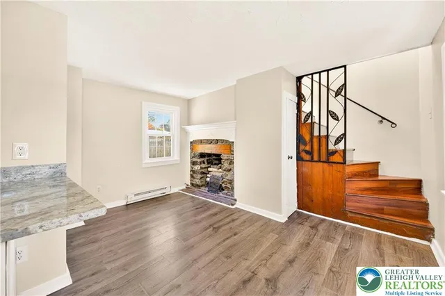 a view of a livingroom with wooden floor and stairs
