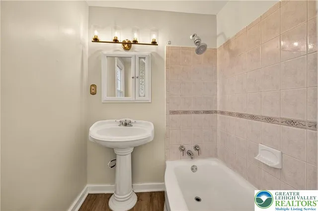 a bathroom with a sink a mirror and a bathtub