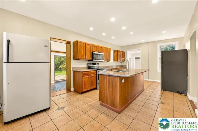 a kitchen with stainless steel appliances granite countertop a refrigerator and a stove