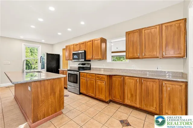 a kitchen with stainless steel appliances granite countertop wooden cabinets a stove top oven a sink and dishwasher