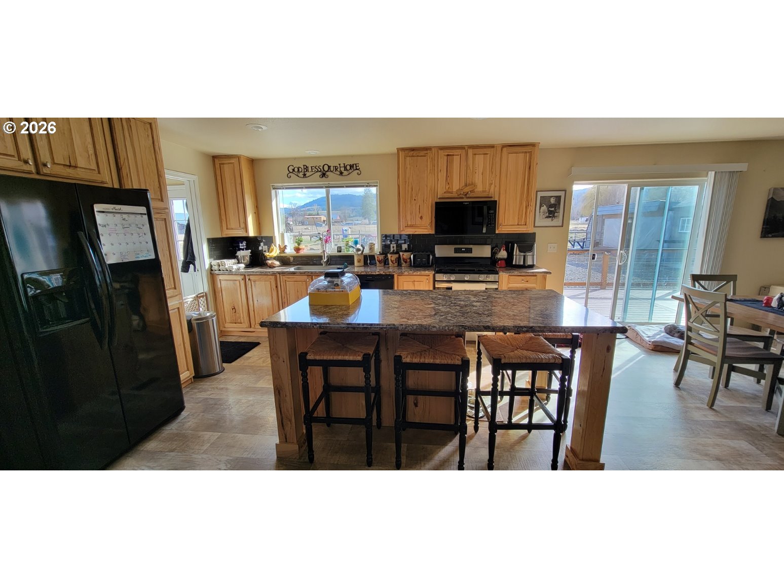 70724 Bear Creek Road Wallowa, OR 97885 - Photo 5 of 44 a dining area with stainless steel appliances kitchen island granite countertop a dining table and chairs