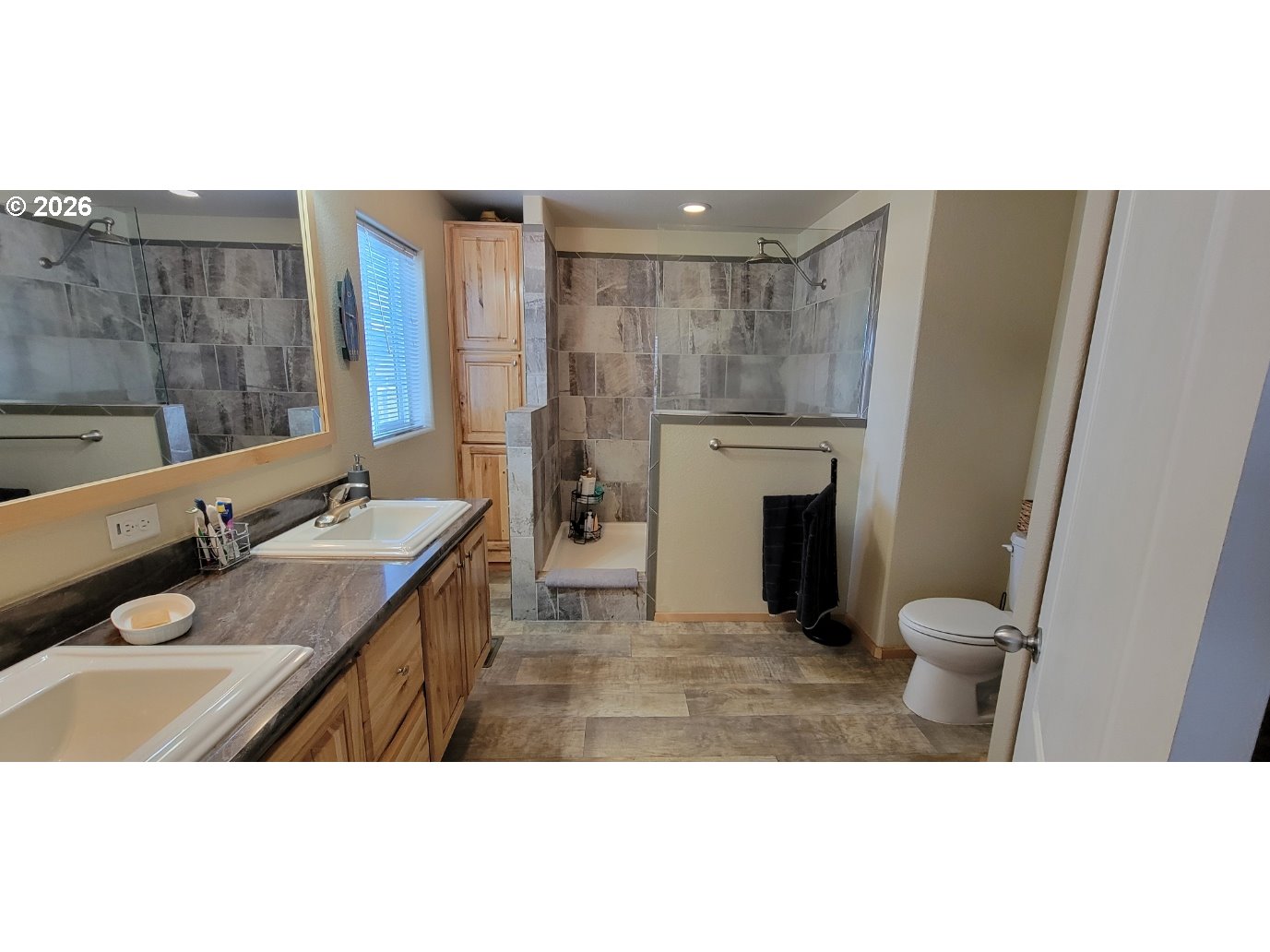 70724 Bear Creek Road Wallowa, OR 97885 - Photo 10 of 44 a bathroom with a granite countertop toilet a sink and a mirror