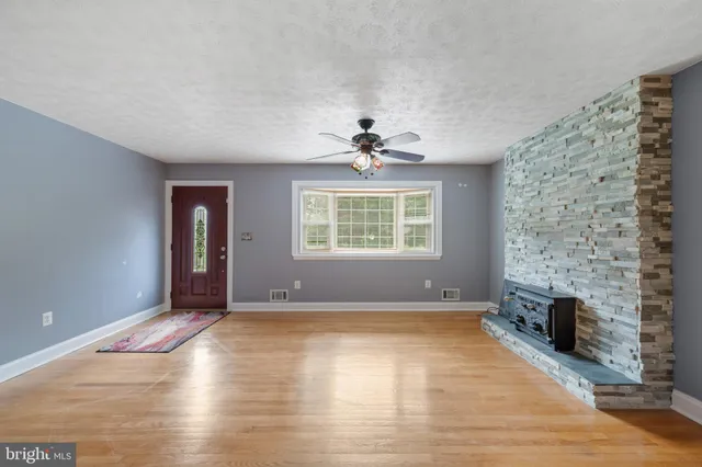 an empty room with windows and fireplace