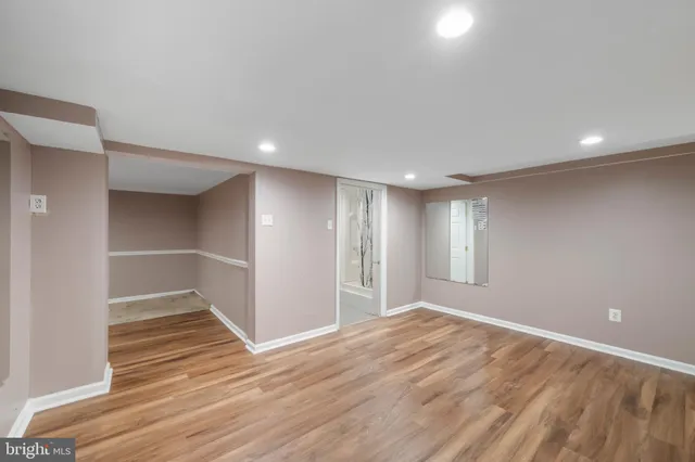 a view of an empty room with wooden floor and closet