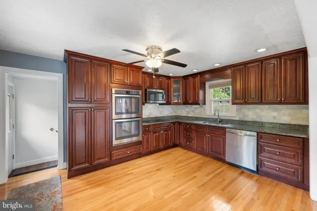 a kitchen with stainless steel appliances granite countertop a refrigerator and cabinets