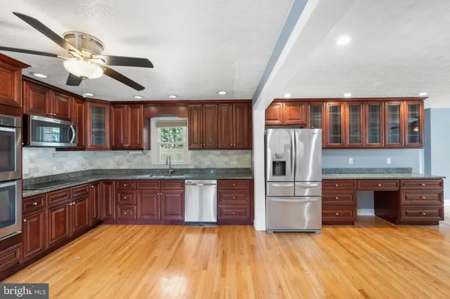 a kitchen with stainless steel appliances granite countertop a kitchen island wooden cabinets and a sink