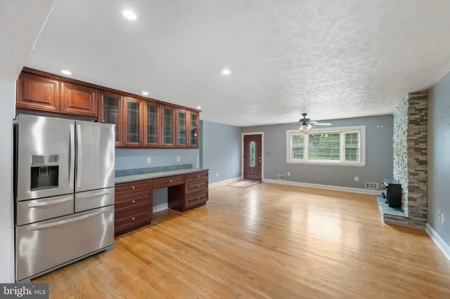 a kitchen with stainless steel appliances granite countertop a refrigerator a stove and a wooden floors