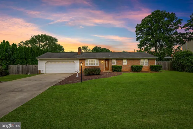 a front view of a house with a yard and trees