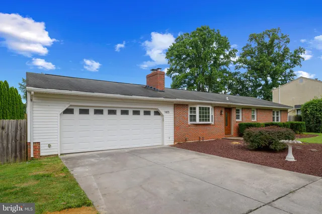 a front view of house with yard and trees in the background
