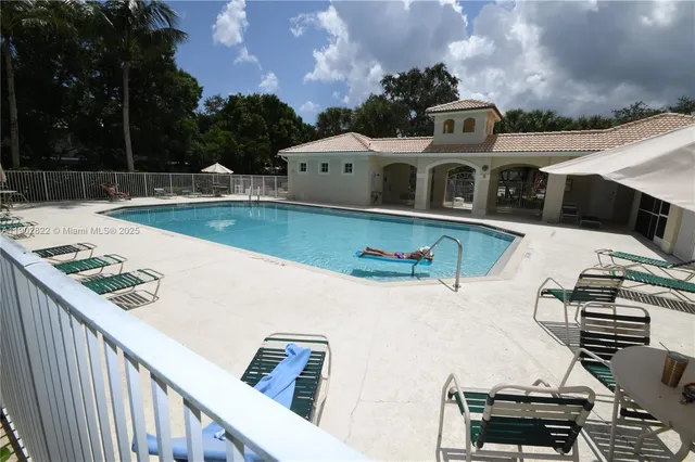 a view of a house with pool and chairs