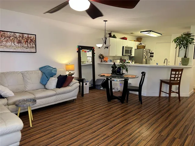 a living room with furniture and view of kitchen