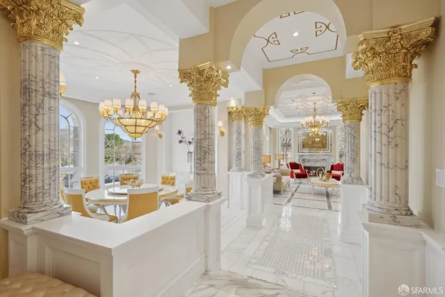 a living room with furniture a fireplace and a chandelier