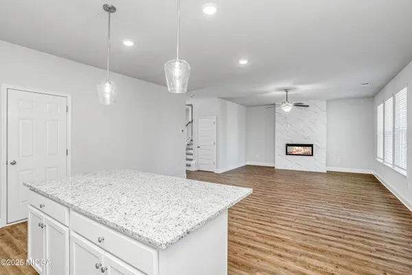 an empty room with kitchen appliances and wooden floor