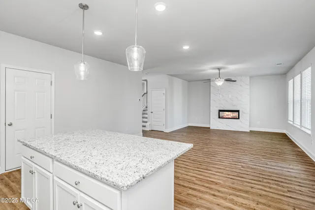 an empty room with kitchen appliances and wooden floor