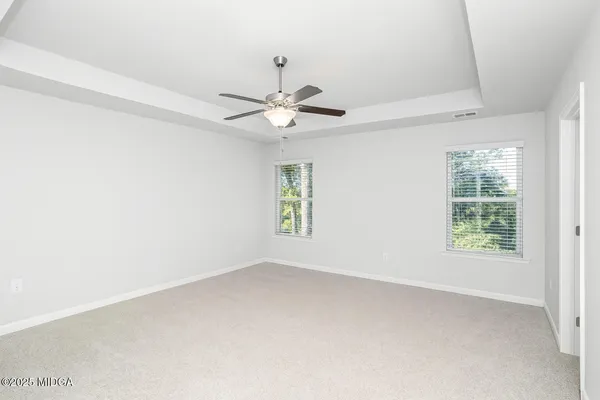 an empty room with a window and a fan