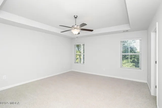 an empty room with a window and a fan