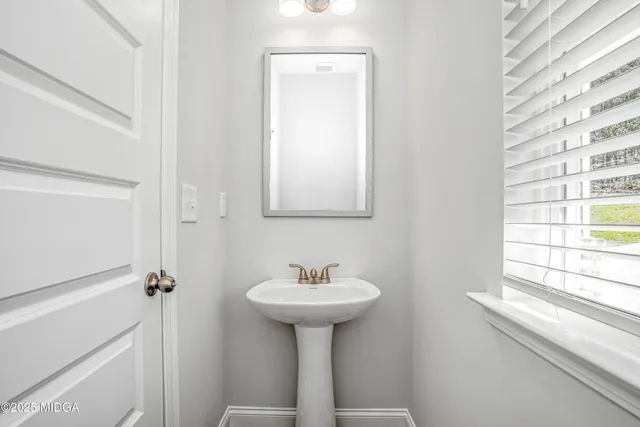 a bathroom with a sink a mirror and a window