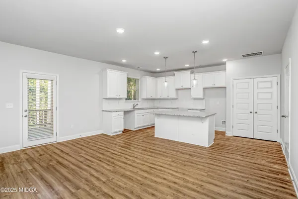 a large kitchen with kitchen island a sink stainless steel appliances and cabinets