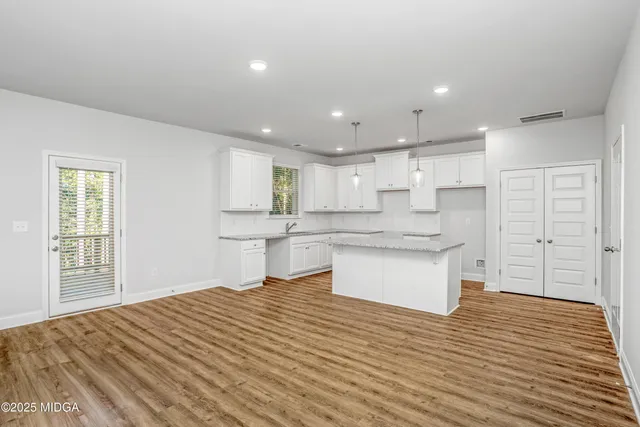 a large kitchen with kitchen island a sink stainless steel appliances and cabinets