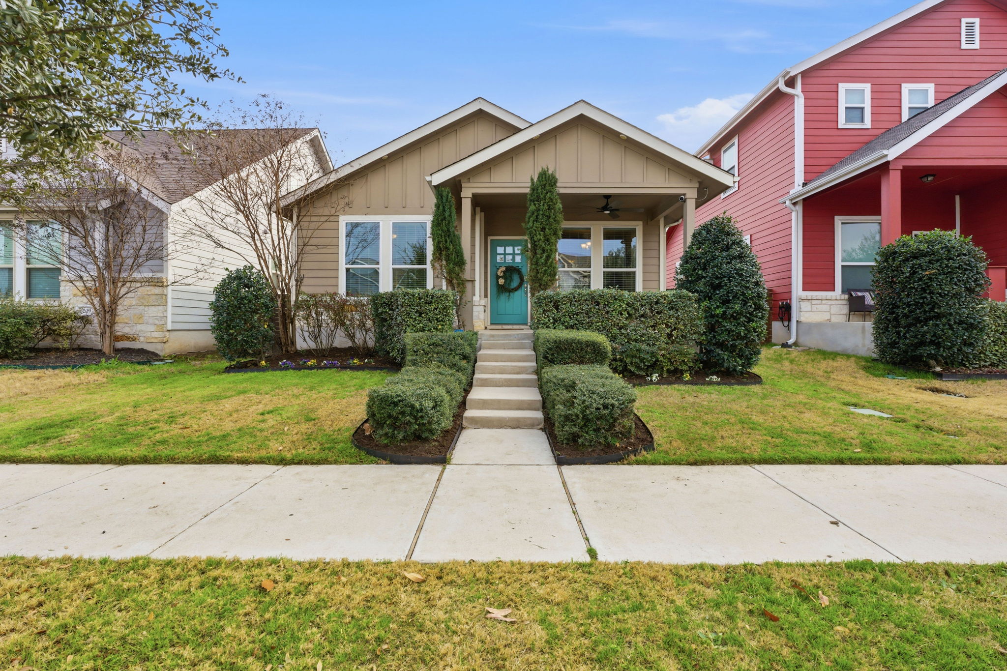 Bungalow-style house with board and batten siding, a front lawn, a ceiling fan, and covered porch