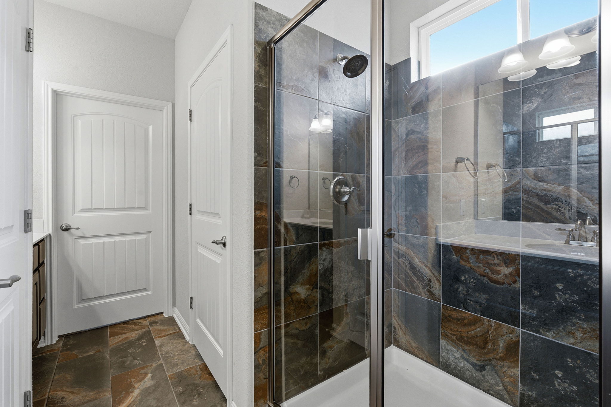 6005 Baythorne Drive Austin, TX 78747 - Photo 20 of 40 Full bathroom with dark stone finish floors, a stall shower, and vanity
