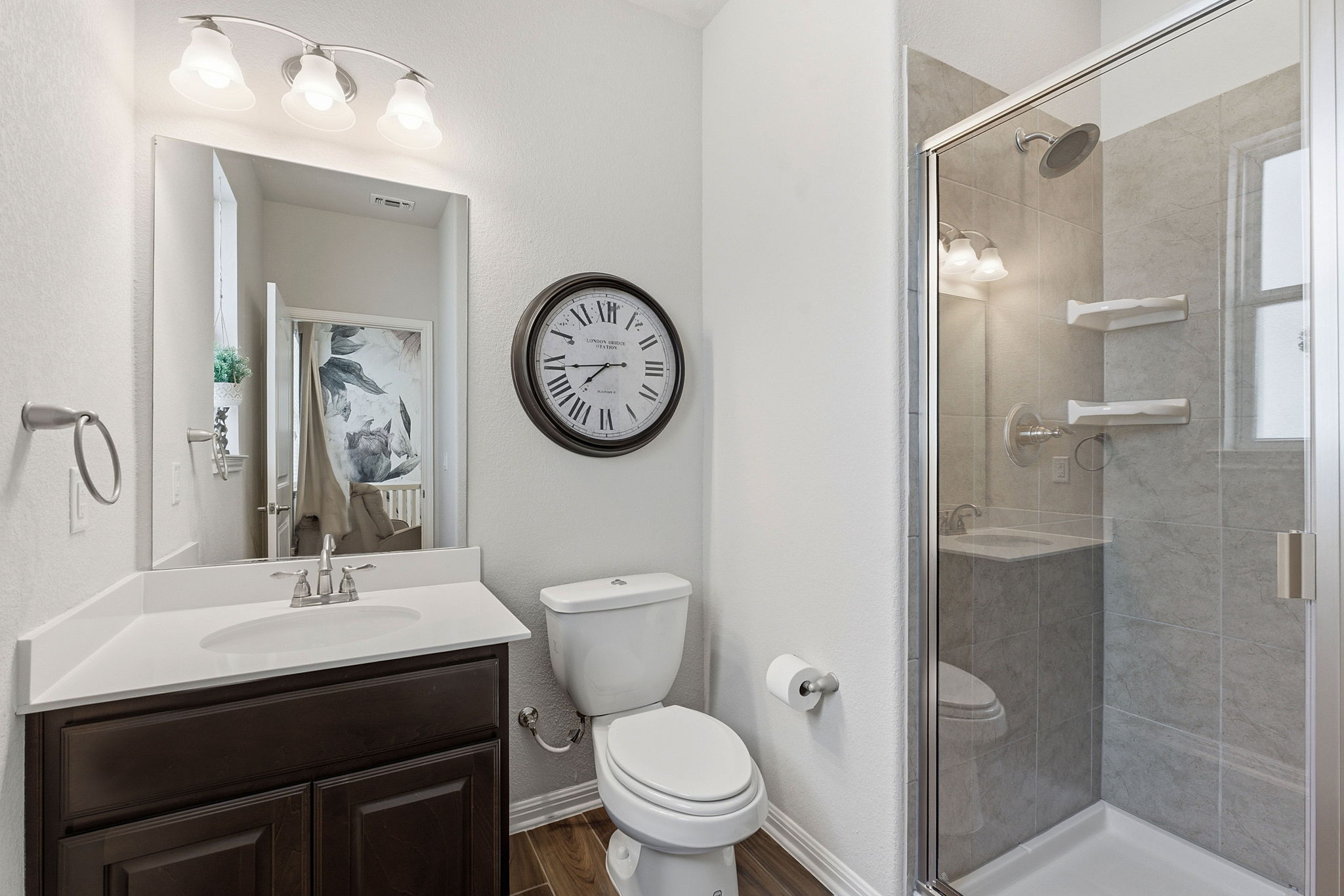 6005 Baythorne Drive Austin, TX 78747 - Photo 23 of 40 Bathroom featuring vanity, a stall shower, and dark wood finished floors