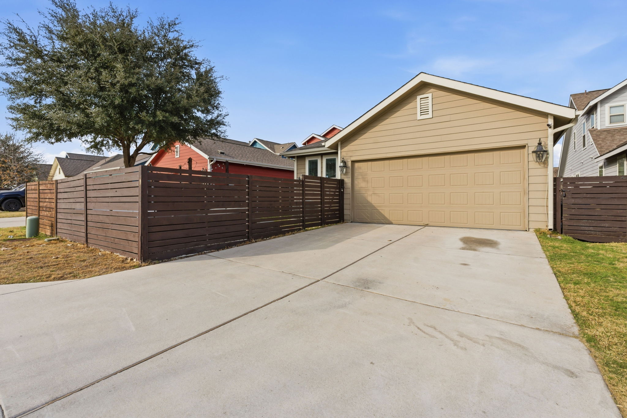 6005 Baythorne Drive Austin, TX 78747 - Photo 28 of 40 View of side of property with driveway, a garage, and a gate