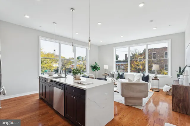 a large white kitchen with a large window a sink and appliances