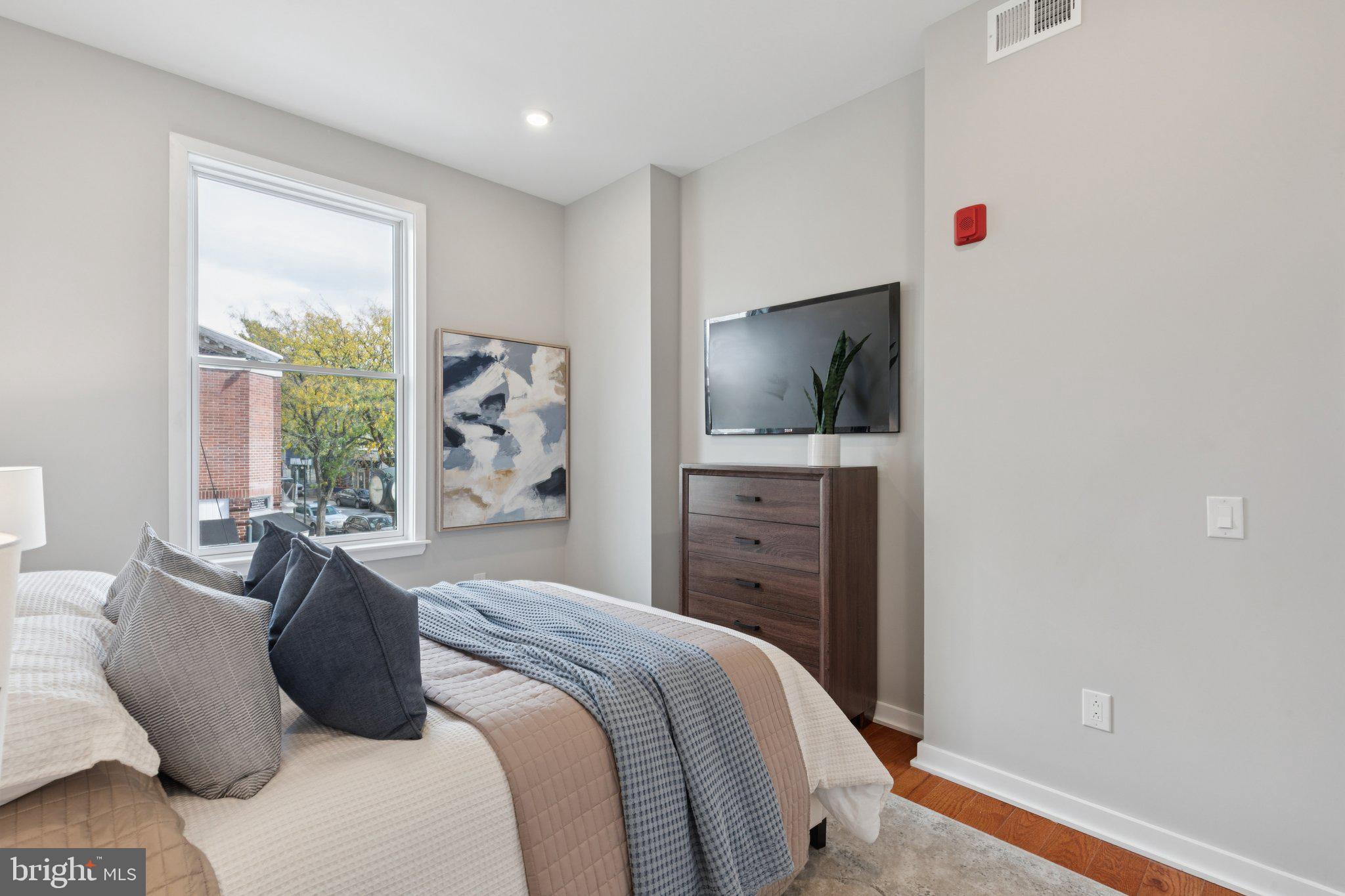 100 Forrest Avenue, Unit 203 Narberth, PA 19072 - Photo 20 of 29 a bedroom with a bed and a flat screen tv