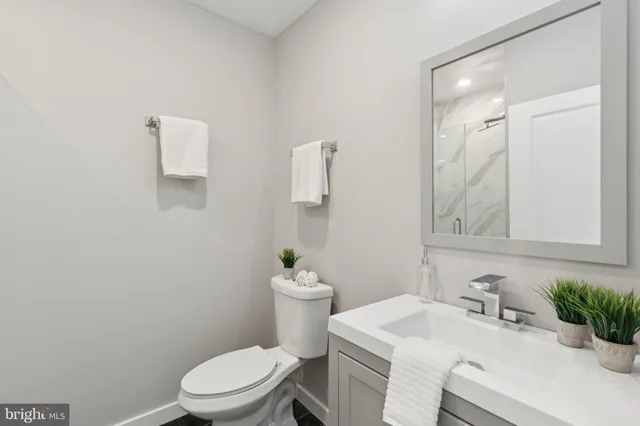 a bathroom with a sink vanity mirror and toilet