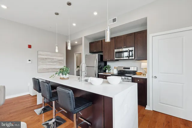 a kitchen with a table chairs refrigerator and microwave