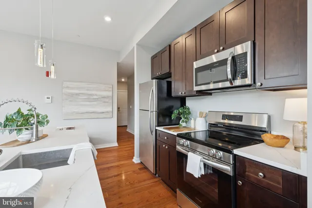 a kitchen with stainless steel appliances granite countertop a stove a microwave and a sink