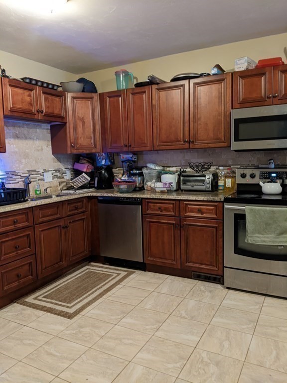 121 Winfield Street Worcester, MA 01602 - Photo 13 of 42 a kitchen with stainless steel appliances granite countertop a stove a sink and a microwave