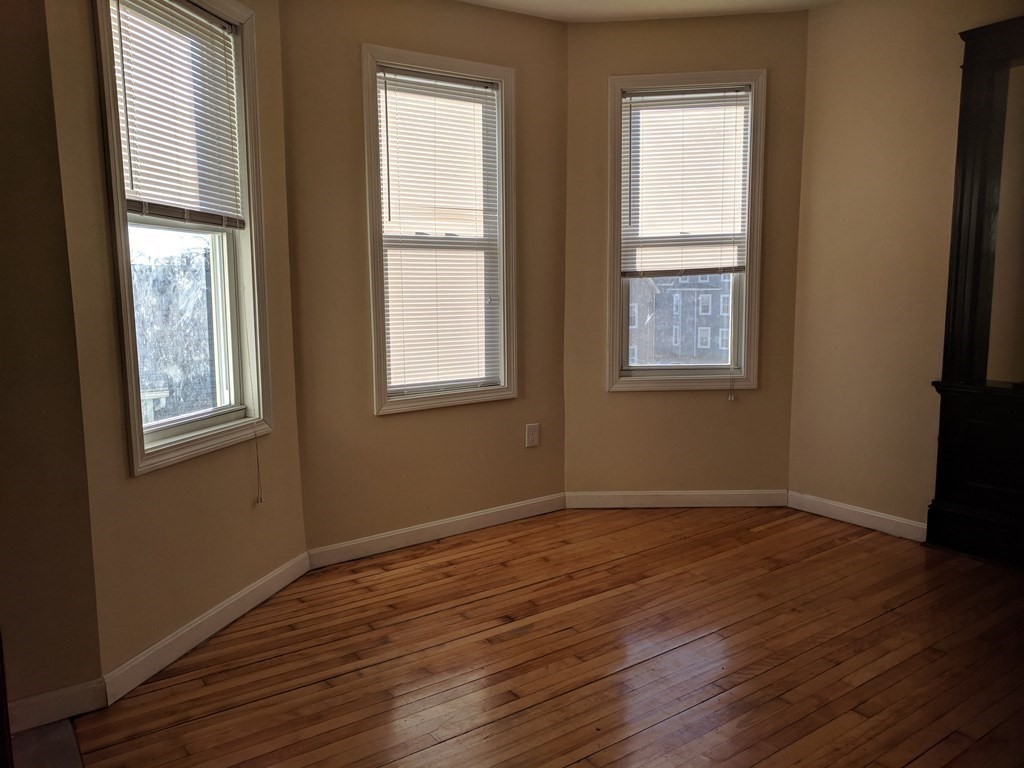 121 Winfield Street Worcester, MA 01602 - Photo 15 of 42 a view of an empty room with wooden floor and a window