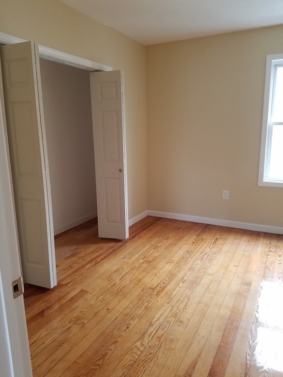 121 Winfield Street Worcester, MA 01602 - Photo 29 of 42 an empty room with wooden floor and windows
