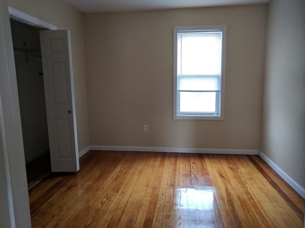 121 Winfield Street Worcester, MA 01602 - Photo 30 of 42 an empty room with wooden floor and windows